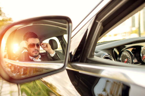 Business man in side mirror of a car - 写真・画像