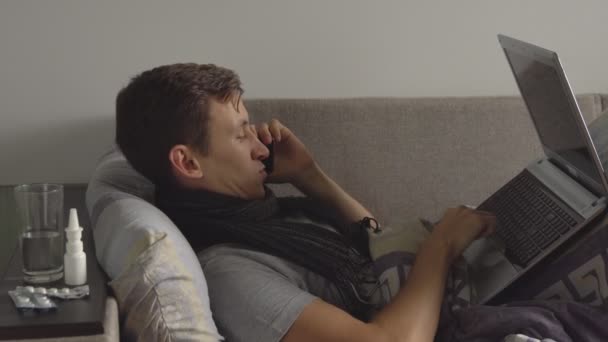 jeune homme malade au lit travaillant sur un cahier et parlant au téléphone. Beaucoup de pilules et de médicaments sont sur la table de chevet
 - Séquence, vidéo