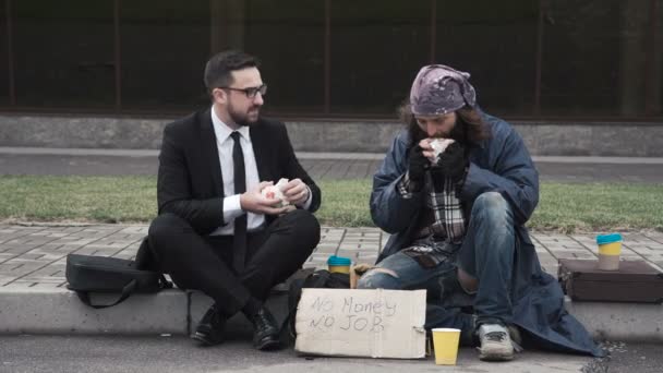 Empresario comunicándose con personas sin hogar
 - Imágenes, Vídeo