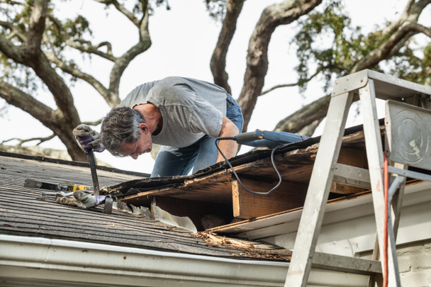 Man Examining and Repairing Leaking House Roof - Photo, Image