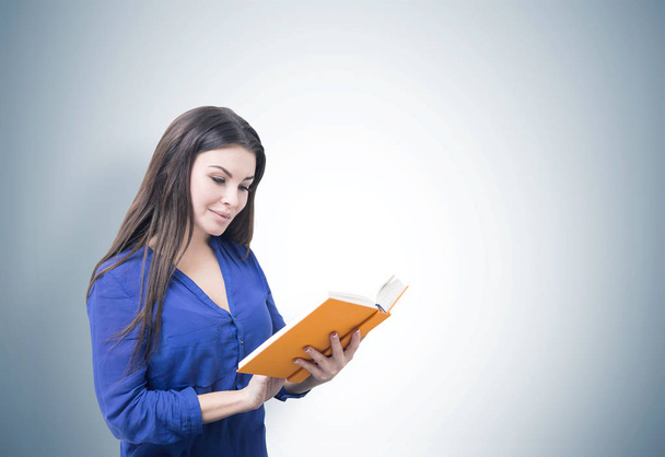 Woman in blue reading a book, gray - Фото, изображение