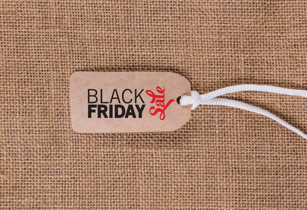 tag with an inscription black Friday on a wicker background - Foto, afbeelding
