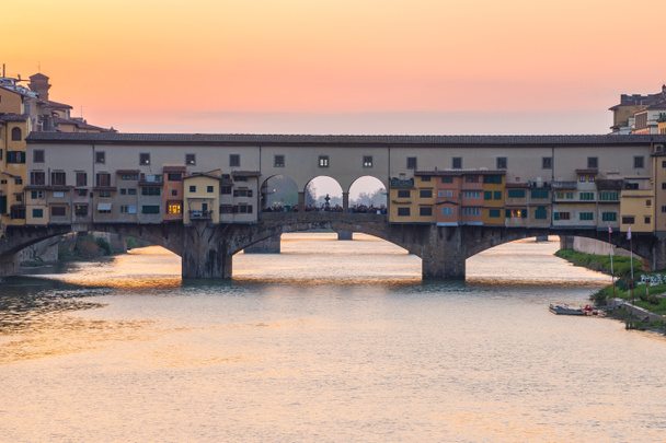 Вид на закат на мост Понте Веккьо во Флоренции, Тоскана, Италия
 - Фото, изображение