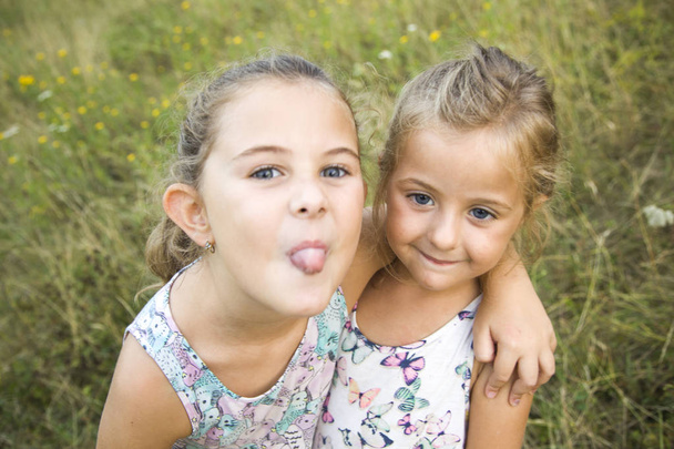 İki kız kardeş - oynamak başka aga bir yandan kapakları ağzıyla - Fotoğraf, Görsel