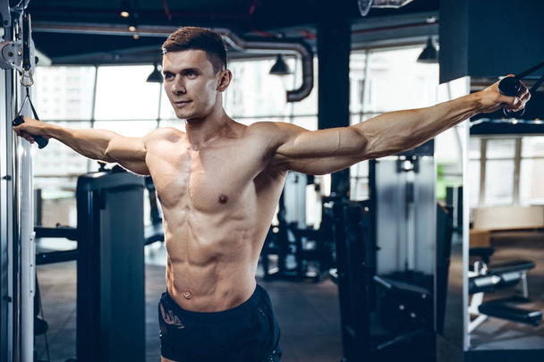 Brutal Caucasian bodybuilder training chest in gym - Photo, Image