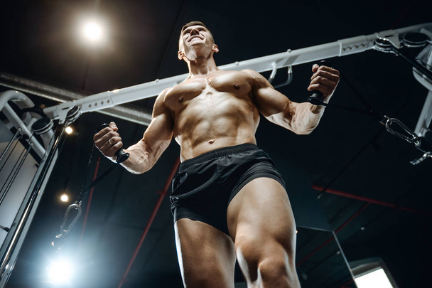 Brutal Caucasian bodybuilder training chest in gym - Zdjęcie, obraz