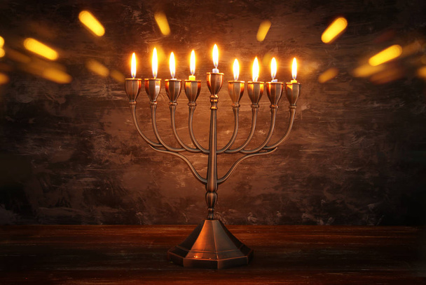 Low key image of jewish holiday Hanukkah background with menorah (traditional candelabra) and burning candles - Foto, Bild