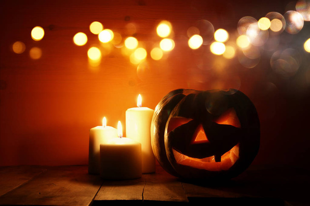 Halloween Pumpkin on wooden table in front of spooky dark background. Jack o lantern - Foto, Imagem
