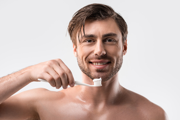 Hymyilevä mies hammasharjalla
   - Valokuva, kuva