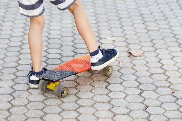 kleiner Stadtjunge mit einem Groschen-Skateboard. junges Kind reitet in th - Foto, Bild