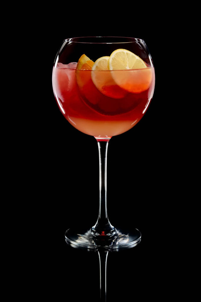 Cold sangria in a wine glass with reflection on black background - Фото, зображення