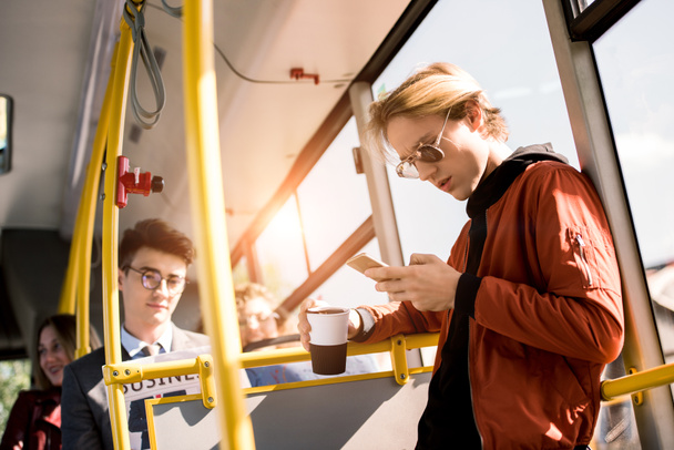 man met smartphone in bus - Foto, afbeelding