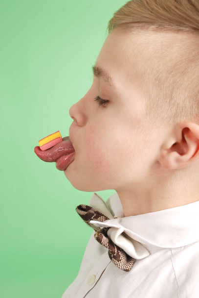 Young boy put the chewing gum on his tongue  - Fotoğraf, Görsel