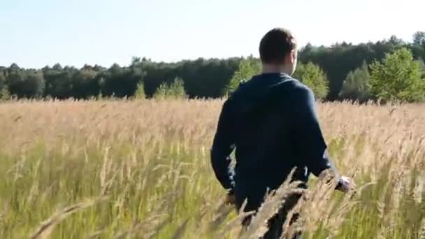 Young Man Walking and Raising Hands in the Field - Metraje, vídeo