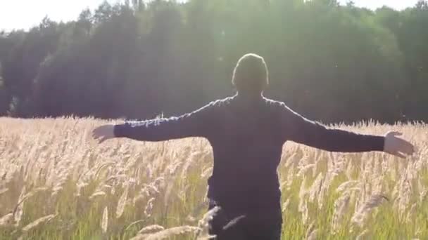 Jovem Caminhando e levantando as mãos no campo
 - Filmagem, Vídeo
