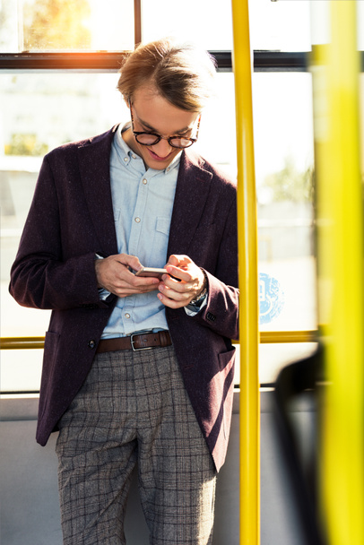 smiling man with smartphone in bus - Fotó, kép