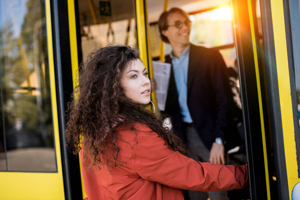 Young woman entering bus - Fotoğraf, Görsel
