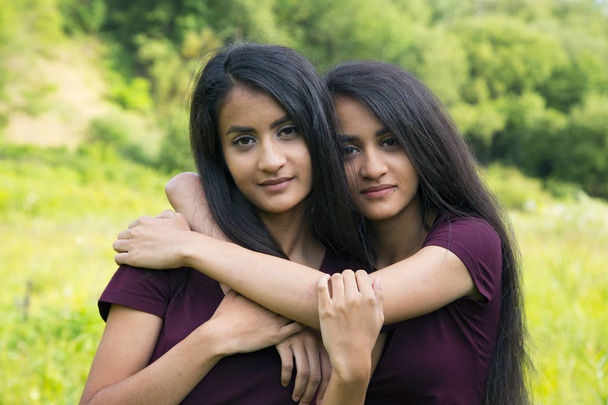 Gémeas femininas abraçam-se
 - Foto, Imagem