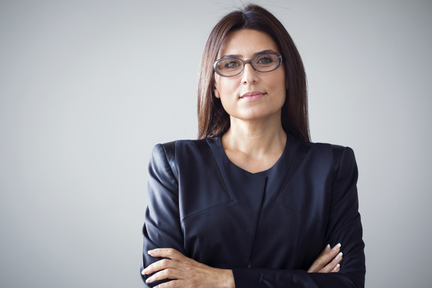 Portrait of businesswoman on grey background - Fotografie, Obrázek