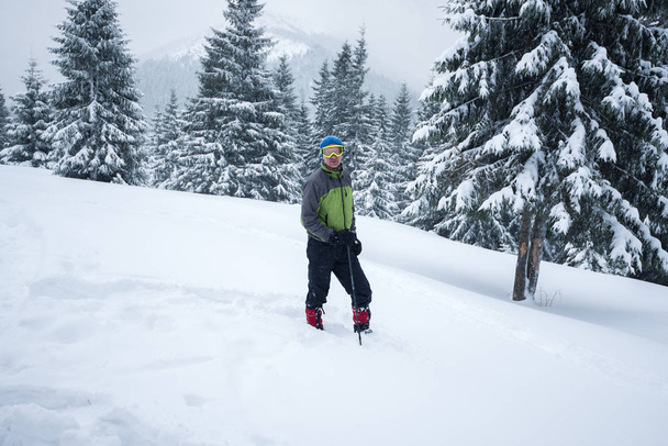 Adventurer, in a goggles, stands in a deep snow  - Foto, immagini