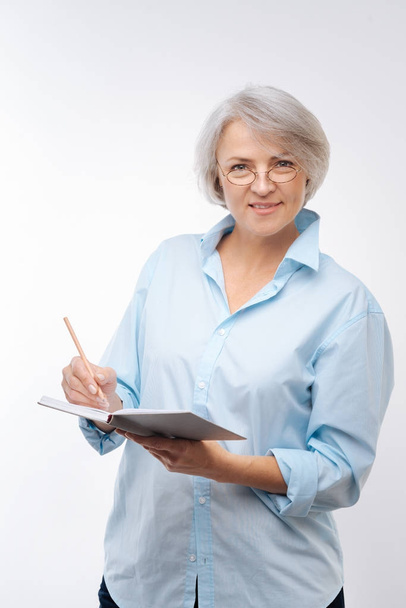 Grey-haired woman posing with open notebook - Foto, Imagen