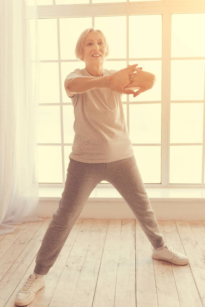 Полная длина в возрасте радостной женщины, делающей утренние упражнения
 - Фото, изображение