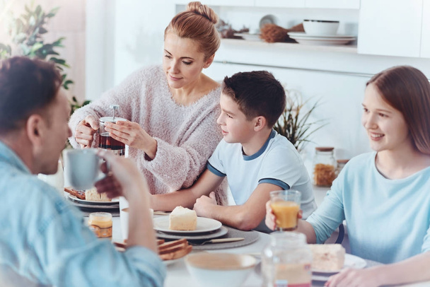 Thoughtful mother taking care of family during breakfast - Photo, Image