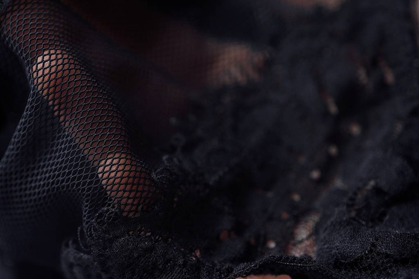 Beautiful delicate openwork black lace in hand - 写真・画像