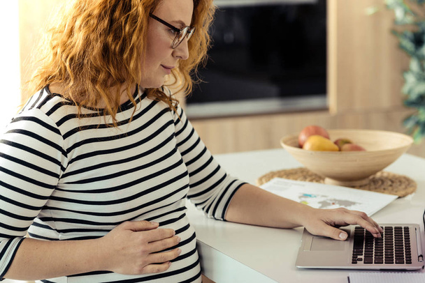 Clever pregnant woman spending time on work - Foto, Imagem