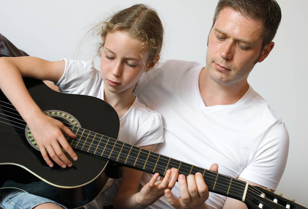 Papa bringt Tochter das Gitarrespielen bei. - Foto, Bild