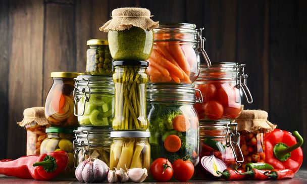 Frascos com alimentos marinados e produtos hortícolas orgânicos crus
 - Foto, Imagem