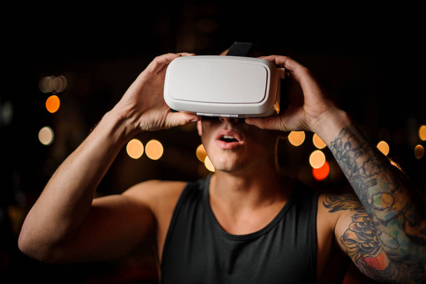 Man wearing VR headset 3D glasses delightfully looking up with his mouth open - Foto, imagen