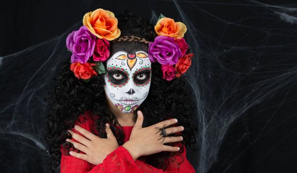 Beetje suiker van schedel meisje het dragen van een meisje Halloween kostuum met wit geschilderde gezicht - Foto, afbeelding