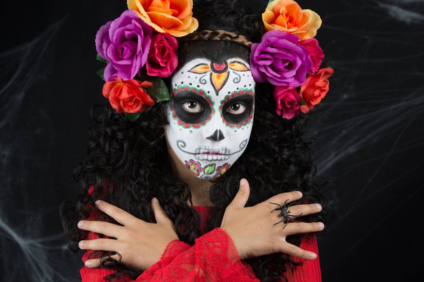 Beetje suiker van schedel meisje het dragen van een meisje Halloween kostuum met wit geschilderde gezicht - Foto, afbeelding