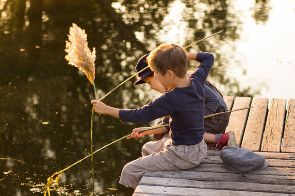 Счастливые дети сидят с палками в руках
 - Фото, изображение
