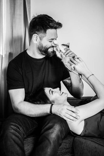 Gorgeous couple with their cat in the house - Photo, Image