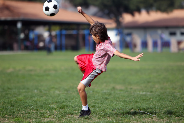 Boy playing soccer or football in the park - Zdjęcie, obraz