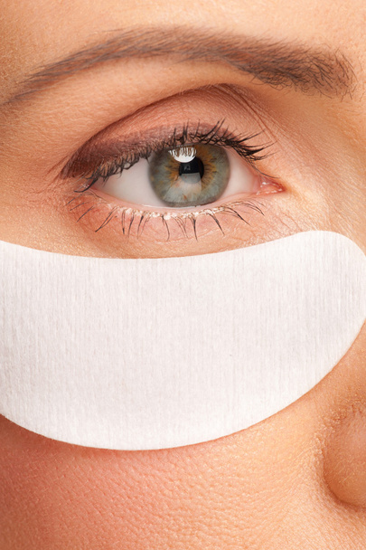 Woman applying gel eye mask - 写真・画像
