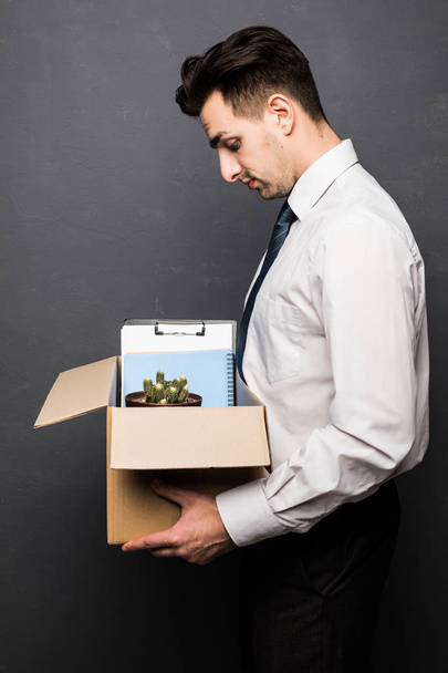 Licenziato uomo d'affari holding box con effetti personali vengono licenziati su grigio
 - Foto, immagini