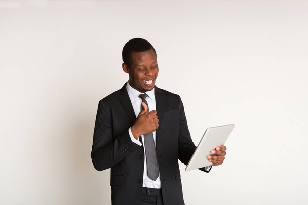Black male posetive manager in suit standing, looking at tablet. Portrait - Foto, Imagen