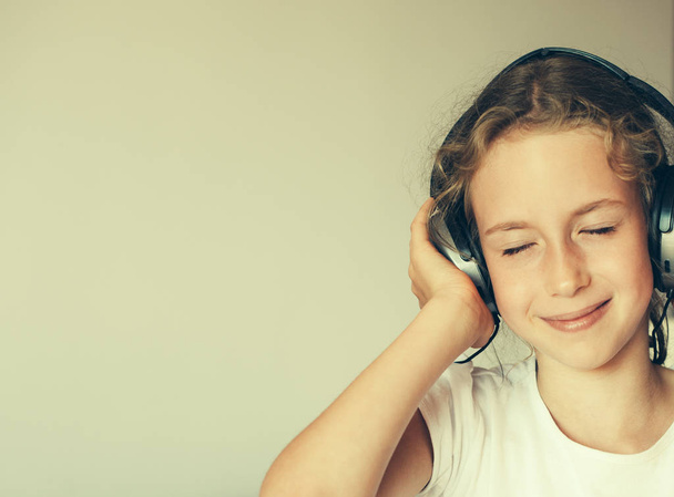 Little girl listening to the music in headphones. - Photo, image