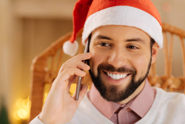 Close up of happy man in Santa hat making calls - Fotó, kép