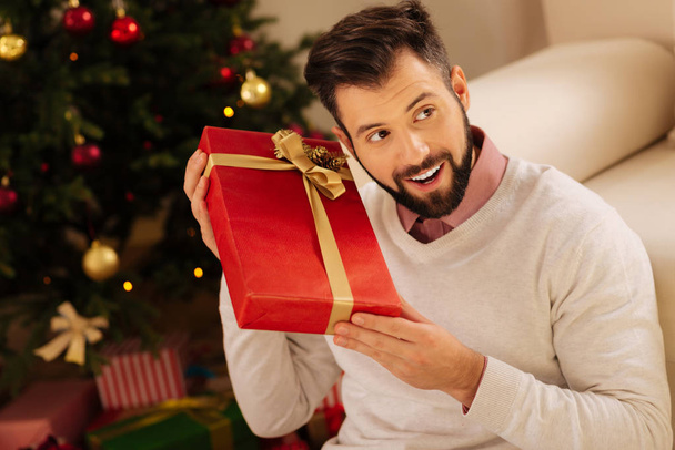 Happy man listening to the sound in gift box - Фото, изображение