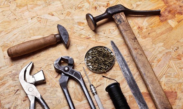 Set of cobbler vintage tools on the wooden background. Top view - Φωτογραφία, εικόνα