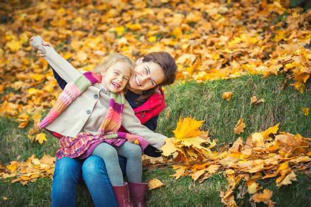 Mother and daughter in the autumn park - Foto, afbeelding