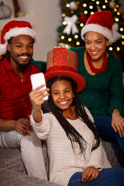 Afro-Amerikaanse familie in Santa hoeden selfie nemen op Kerstmis - Foto, afbeelding