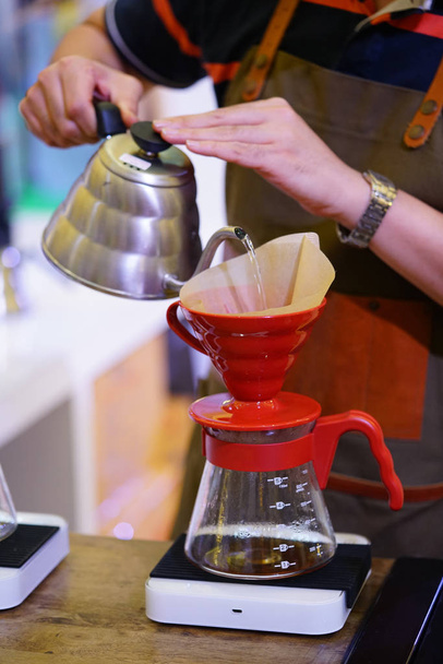 Бариста руки наливая горячую воду в капельную кофеварку
 - Фото, изображение