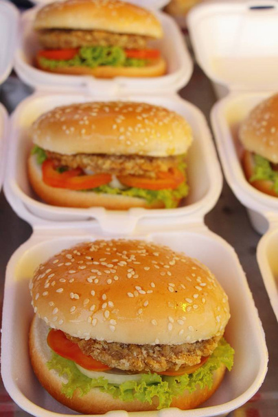Свинячі гамбургери з овочами на вуличній їжі
 - Фото, зображення