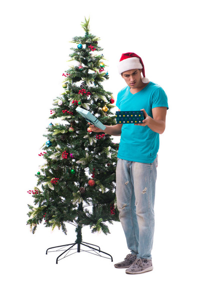 Young man decorating christmas tree isolated on white - Fotó, kép