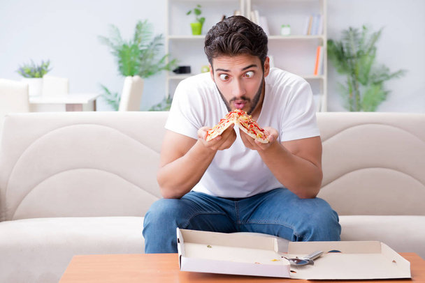 Homme mangeant de la pizza ayant un plat à emporter à la maison détente au repos - Photo, image